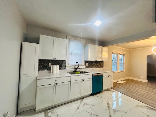 kitchen with black dishwasher, white cabinetry, tasteful backsplash, and sink