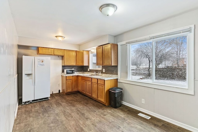 kitchen featuring backsplash, sink, dark wood-type flooring, and white appliances