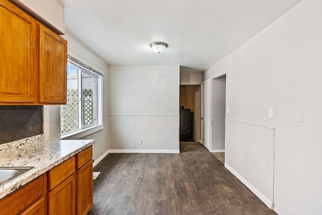 kitchen featuring light stone counters and dark wood-type flooring