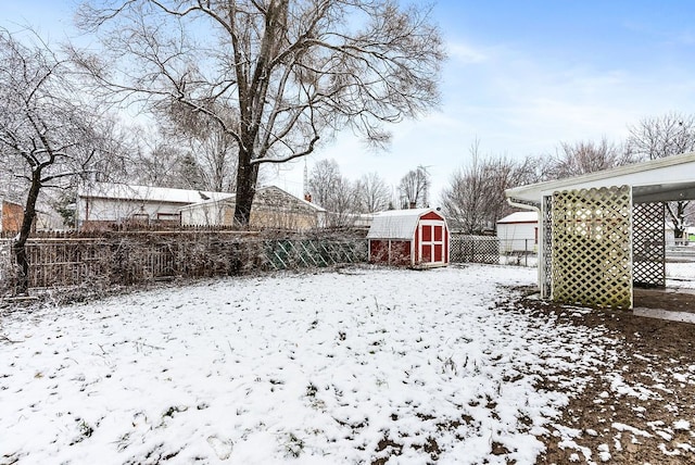 yard layered in snow with a storage unit