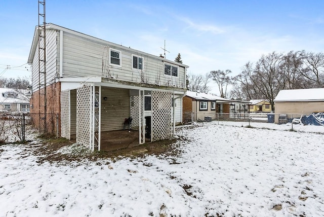 view of snow covered back of property