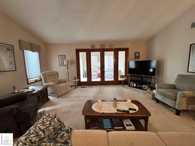 carpeted living room with french doors and lofted ceiling