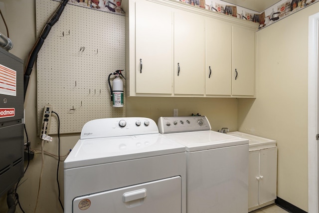 laundry area featuring cabinets, separate washer and dryer, and sink