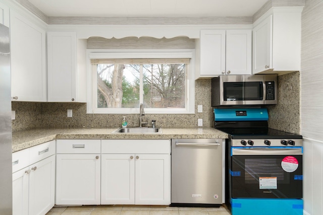 kitchen with white cabinetry, appliances with stainless steel finishes, light tile patterned flooring, and sink