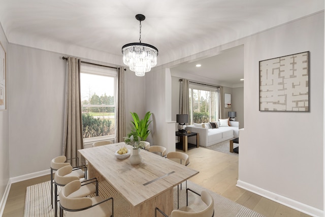 dining area with an inviting chandelier and light wood-type flooring