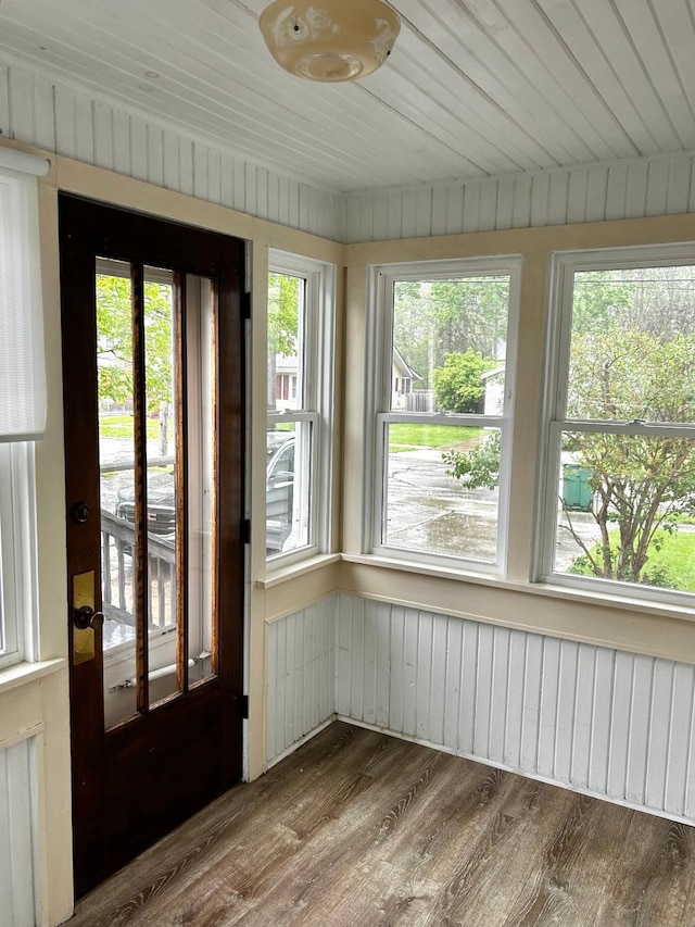 unfurnished sunroom featuring plenty of natural light and wood finished floors