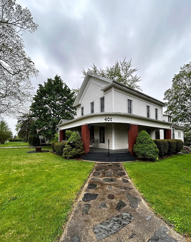 view of front of property with covered porch and a front lawn