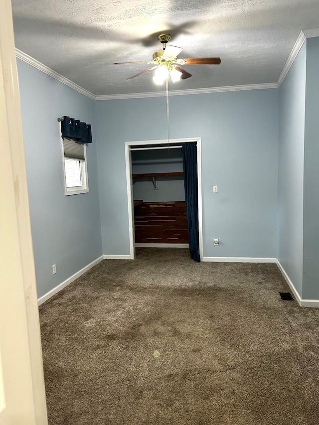 unfurnished room featuring a textured ceiling, ornamental molding, ceiling fan, and carpet