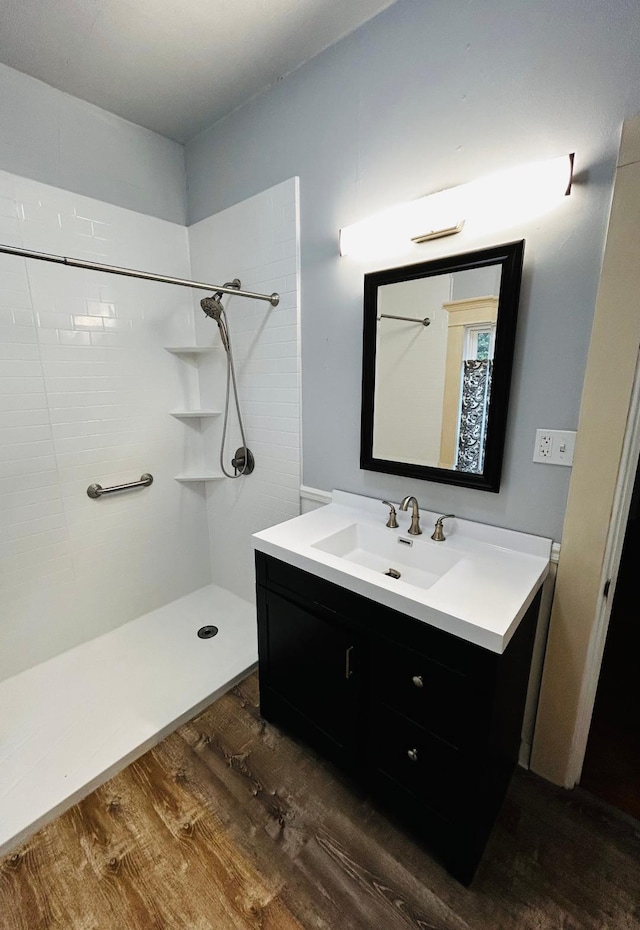 full bathroom with a shower, wood finished floors, and vanity