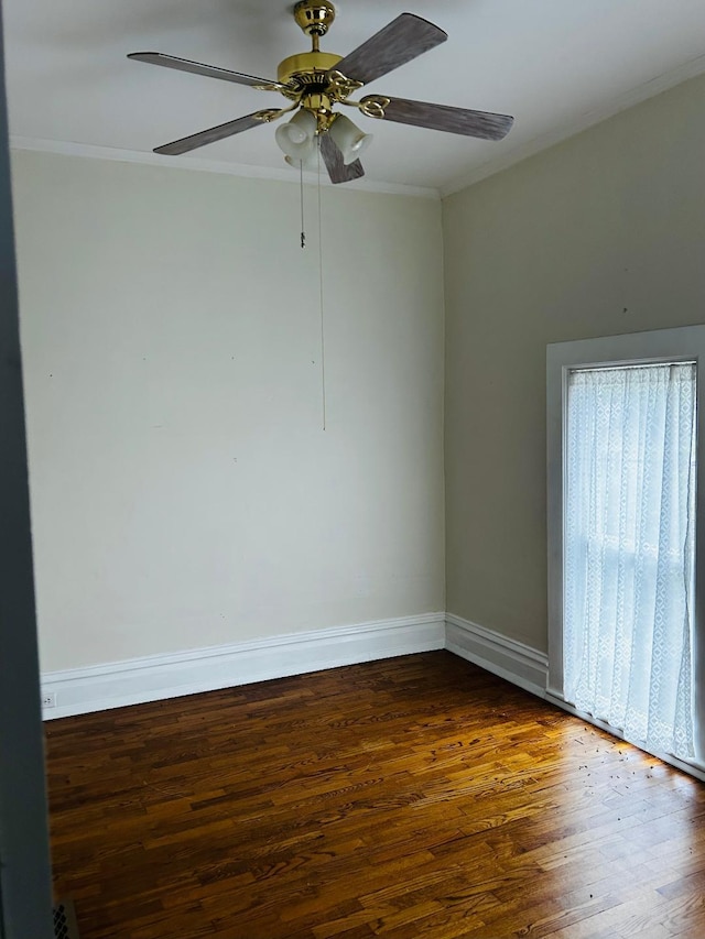empty room with crown molding, baseboards, a ceiling fan, and wood finished floors