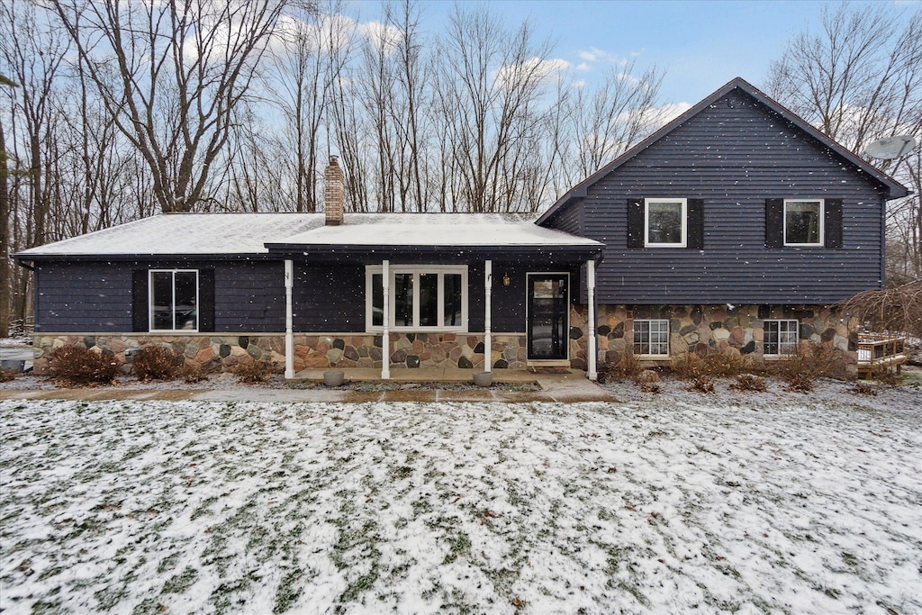 view of snow covered rear of property