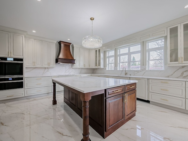 kitchen with a breakfast bar, a center island, hanging light fixtures, a wealth of natural light, and custom range hood