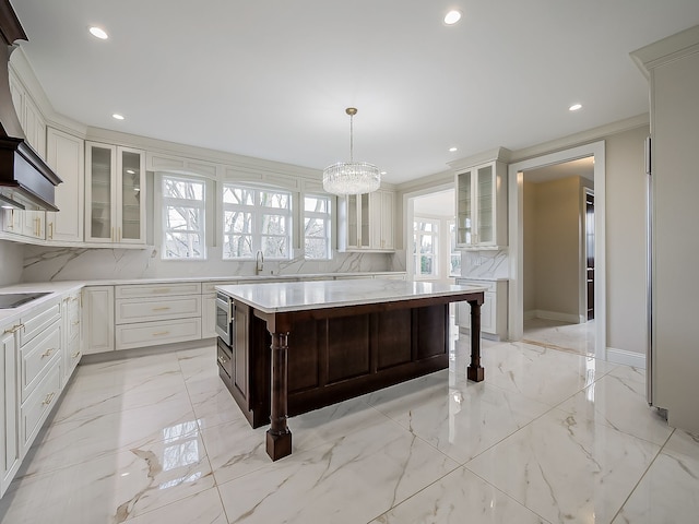 kitchen with pendant lighting, a breakfast bar area, decorative backsplash, black electric stovetop, and a kitchen island