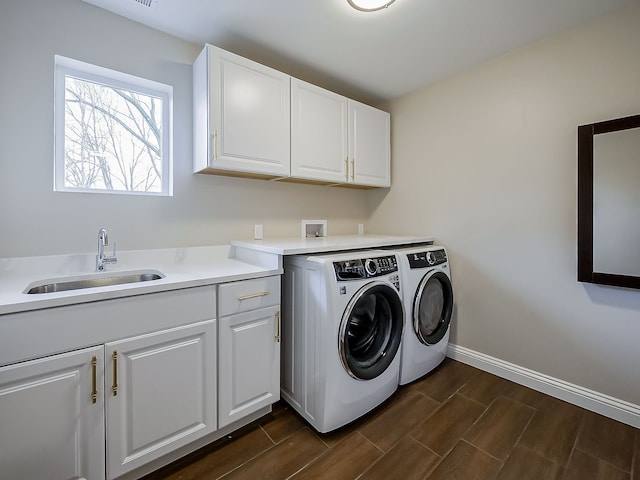 laundry room featuring cabinets, independent washer and dryer, and sink