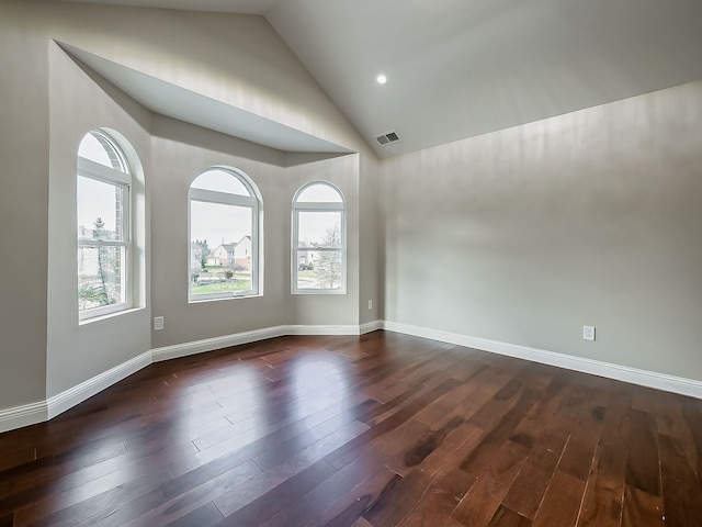 empty room with dark hardwood / wood-style floors, high vaulted ceiling, and a wealth of natural light