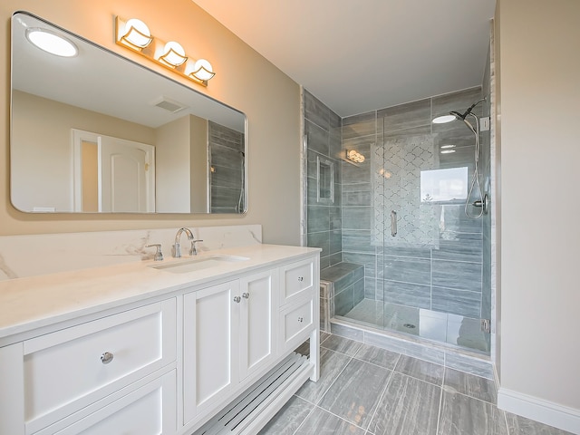 bathroom featuring vanity and a shower with door