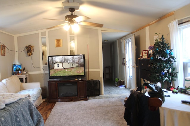 living room with ceiling fan, crown molding, a fireplace, carpet floors, and lofted ceiling