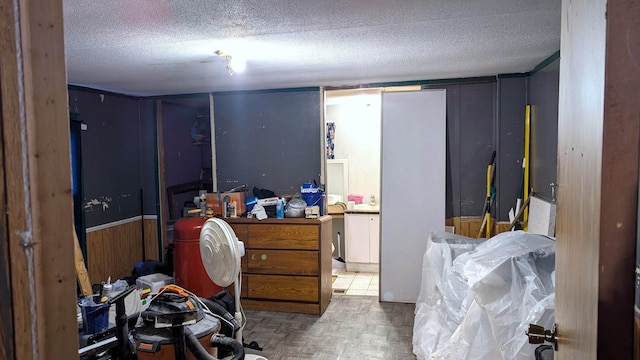 interior space featuring parquet flooring, a textured ceiling, and wooden walls