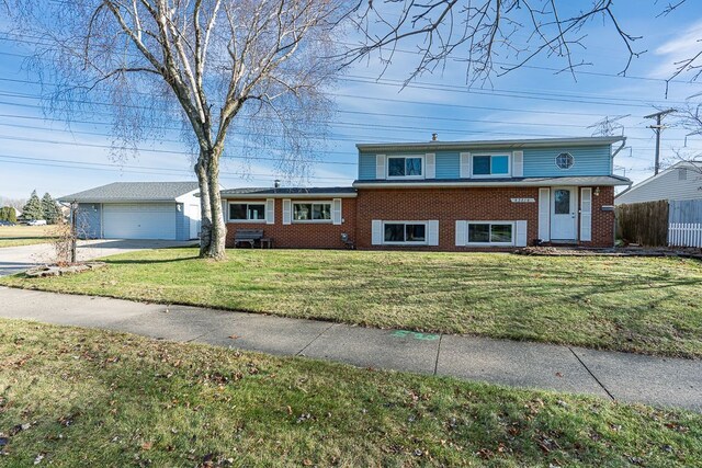 tri-level home featuring a garage, an outdoor structure, and a front lawn