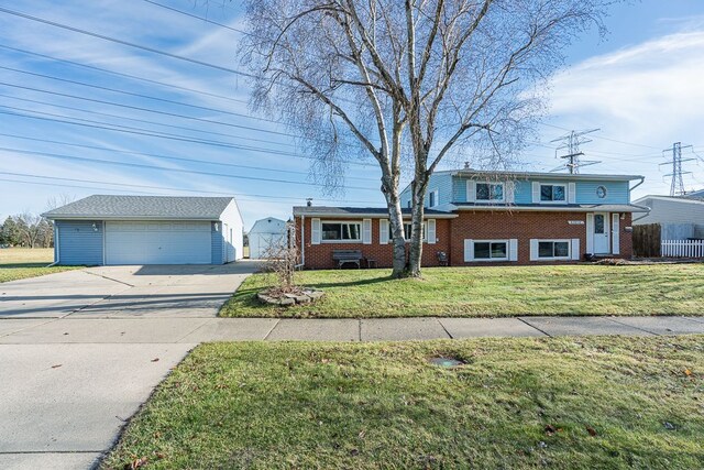 tri-level home with a front lawn, an outdoor structure, and a garage