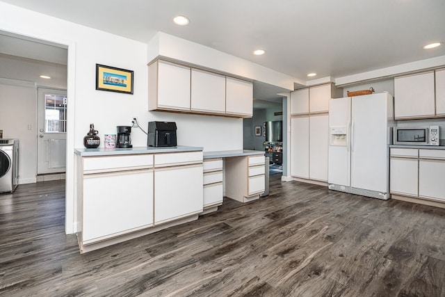 kitchen featuring dark wood-type flooring, washer / clothes dryer, built in desk, and white fridge with ice dispenser