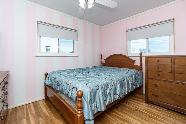 bedroom featuring multiple windows, ornamental molding, and light hardwood / wood-style floors