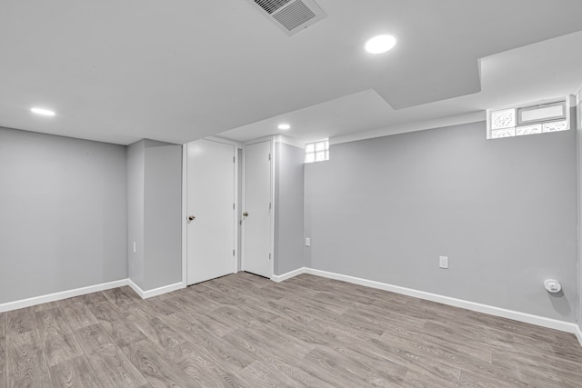 basement with light hardwood / wood-style floors and a wealth of natural light