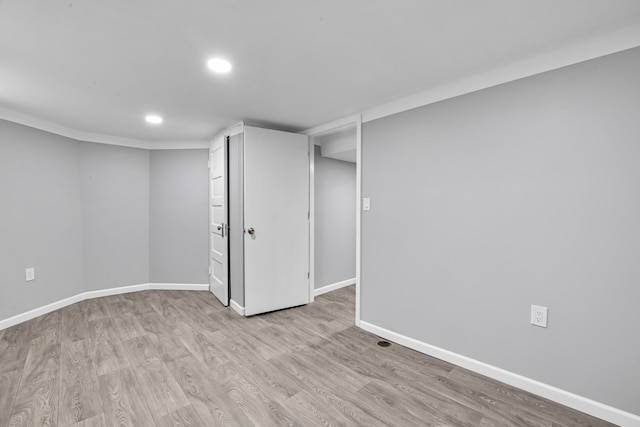 basement featuring crown molding and light wood-type flooring