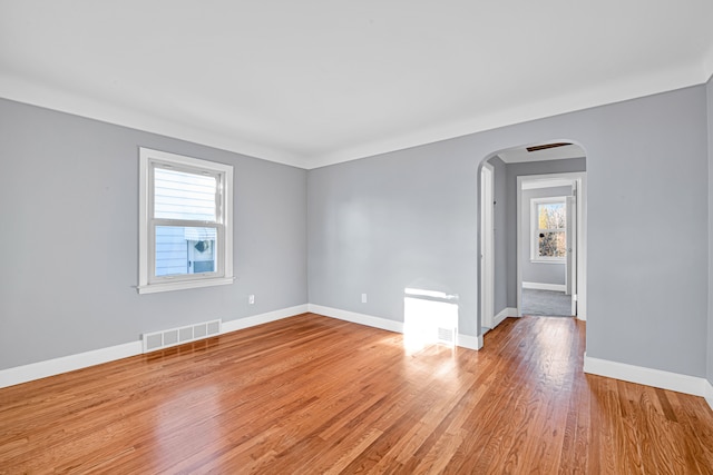 spare room with plenty of natural light and light hardwood / wood-style flooring