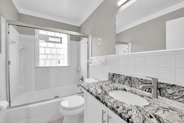 full bathroom featuring vanity, combined bath / shower with glass door, decorative backsplash, toilet, and tile walls