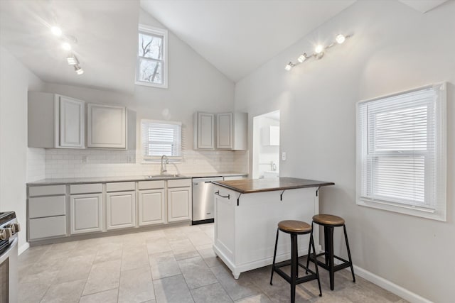 kitchen with sink, stainless steel appliances, kitchen peninsula, a breakfast bar area, and decorative backsplash