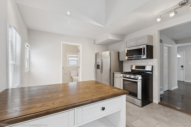 1597 W Saratoga St, Ferndale, MI 48220 - kitchen featuring appliances with stainless steel finishes, decorative backsplash, butcher block countertops, and white cabinetry
