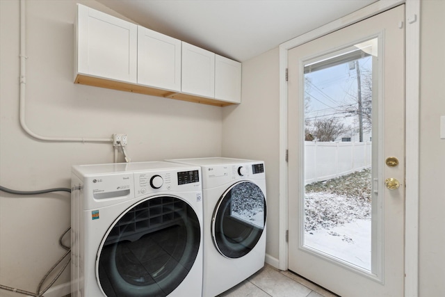 washroom featuring washer and dryer, light tile patterned flooring, and cabinets