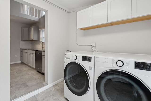 laundry room with cabinets, light tile patterned floors, sink, and washing machine and clothes dryer