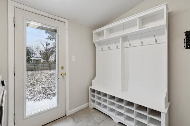 mudroom with a wealth of natural light, light tile patterned flooring, and vaulted ceiling