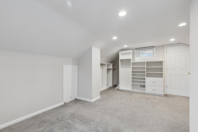 walk in closet with lofted ceiling and light carpet