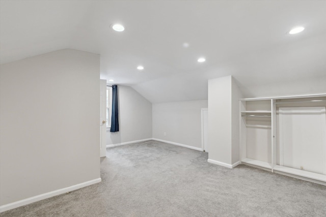 additional living space with light colored carpet and lofted ceiling