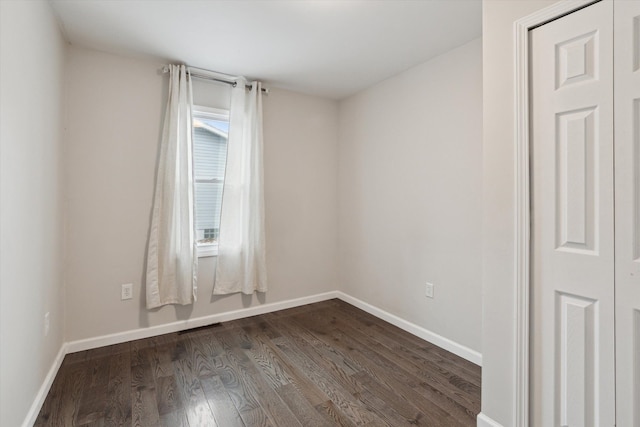 empty room with dark hardwood / wood-style flooring