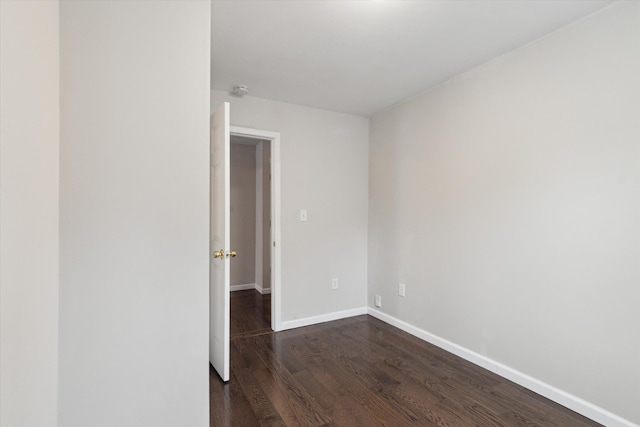 empty room with dark hardwood / wood-style flooring