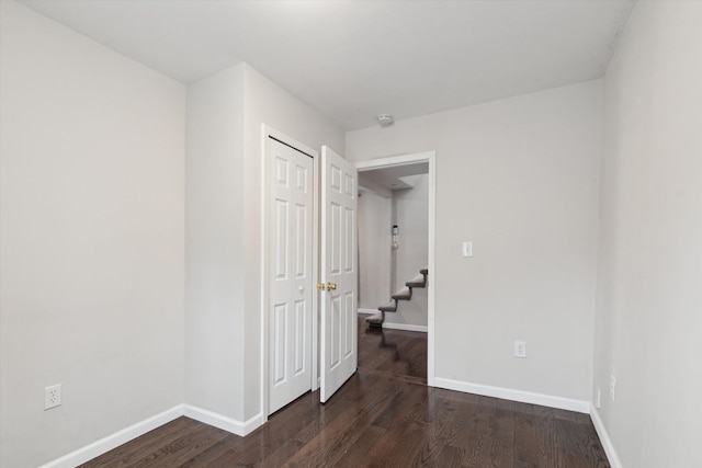 unfurnished bedroom with dark hardwood / wood-style flooring