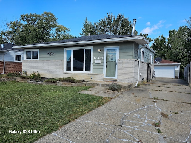 view of front of home with an outbuilding, a garage, and a front lawn