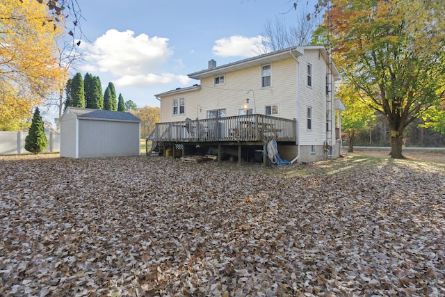 rear view of property featuring a wooden deck and a shed