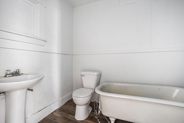 bathroom with toilet, sink, a bathtub, and hardwood / wood-style flooring