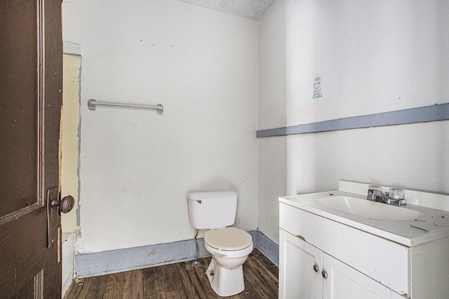 bathroom with hardwood / wood-style floors, vanity, and toilet