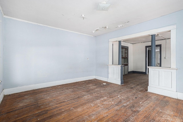 empty room with dark hardwood / wood-style floors and ornamental molding