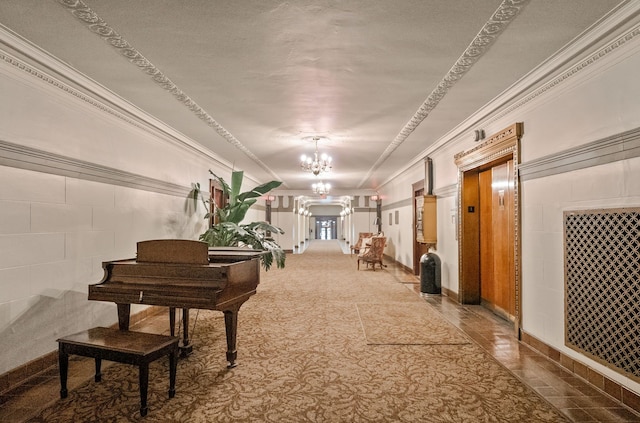 hallway with ornamental molding, elevator, and a notable chandelier