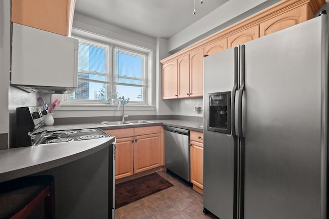 kitchen featuring light brown cabinets, appliances with stainless steel finishes, a sink, and tile patterned floors