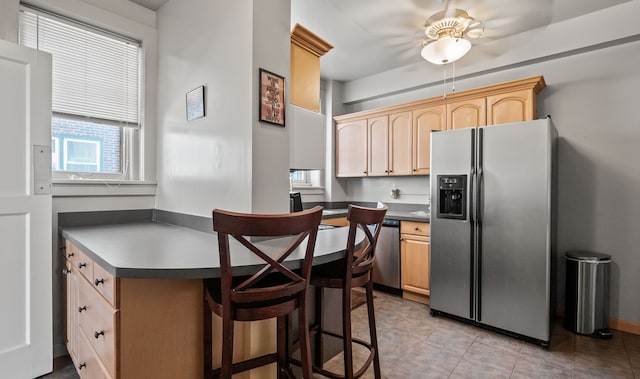 kitchen featuring appliances with stainless steel finishes, dark countertops, and light brown cabinets