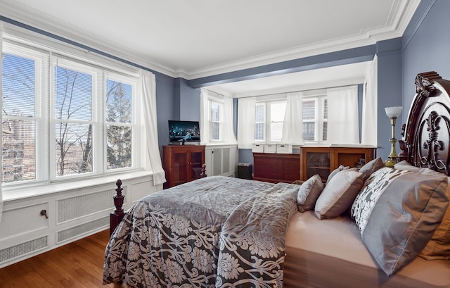 bedroom featuring multiple windows, crown molding, and wood finished floors