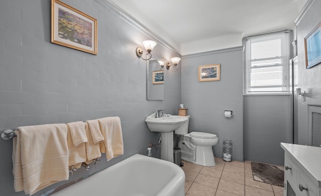 full bath featuring a tub to relax in, tile patterned flooring, and toilet